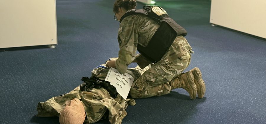 Trainee applying a tourniquet to a training manikin